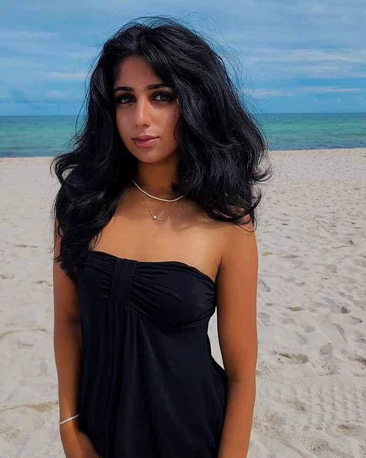 Curva Solitaire Round-cut Moissanite Necklace worn outdoors by the ocean